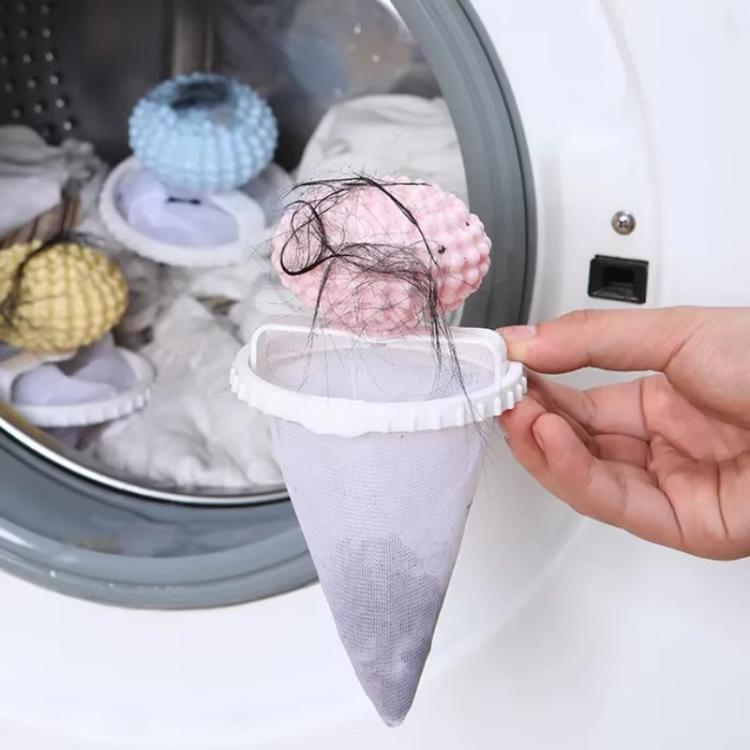 Washing machine hair lint catcher showing pink studded ball over white mesh bag with hair