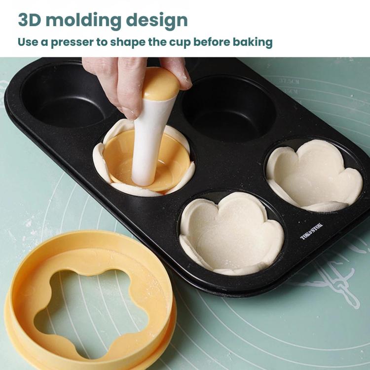 Black multi-cavity cake press mold tray with yellow press shaping heart cup cookies