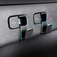 Two black embedded trunk hook holders on textured interior trim panel