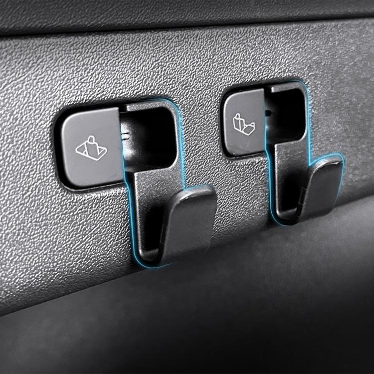 Two black embedded trunk hook holders on textured interior trim panel