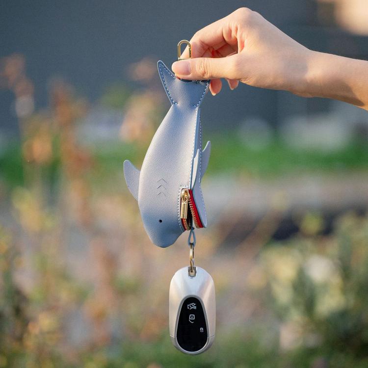 Light blue shark-shaped key cover hanging with red zipper and key ring
