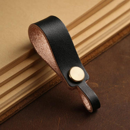 Black leather lanyard keychain with round brass snap and finger-loop end.