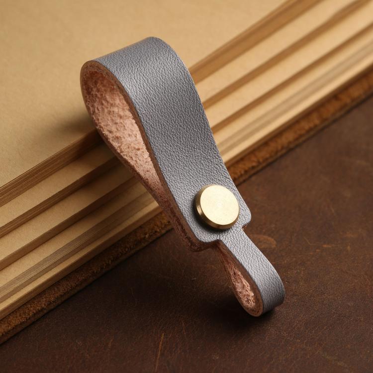Light gray leather lanyard keychain with round brass snap and finger-loop end.