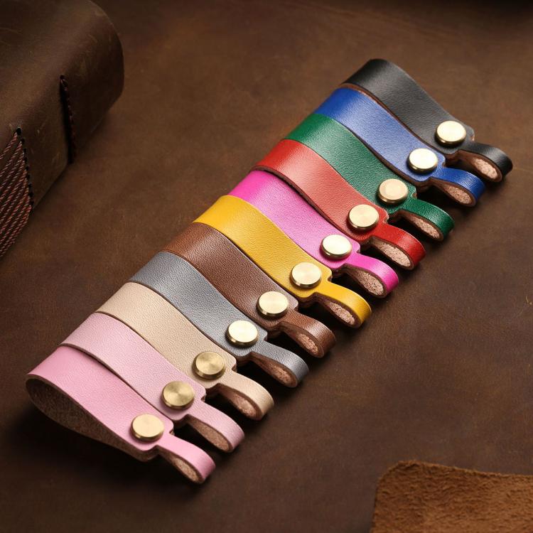 Set of multicolor leather lanyard keychains with round brass snaps on brown base.