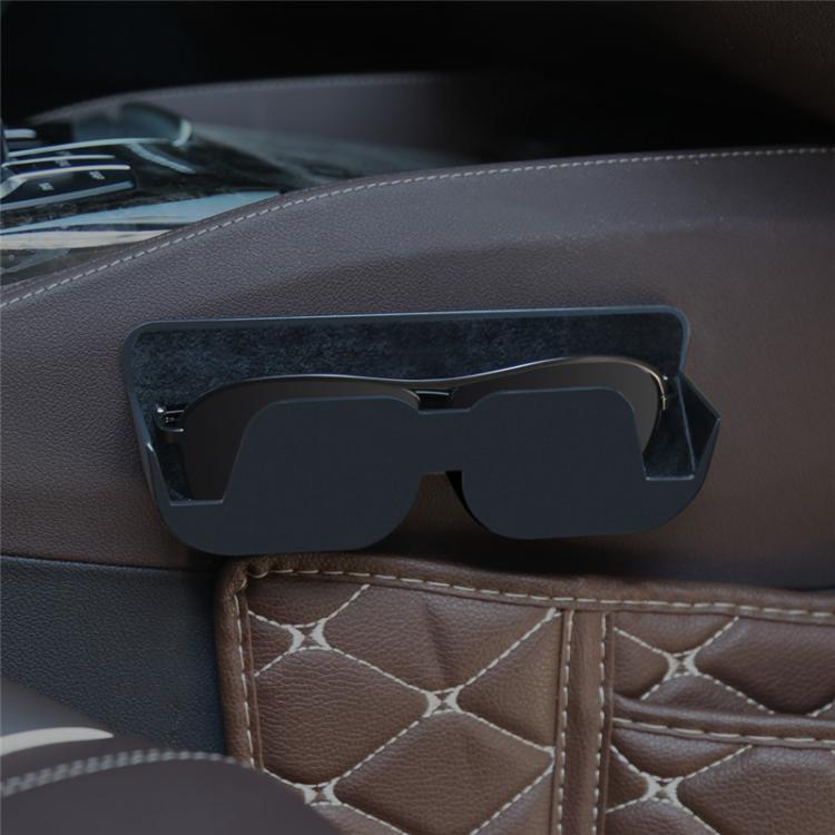 Adhesive car glasses case in black, mounted on a car dashboard