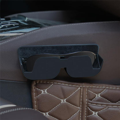 Adhesive car glasses case in black, mounted on a car dashboard