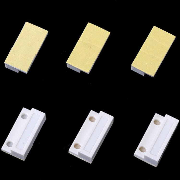 Magnetic door sensor switch contacts, multiple white sensor blocks shown from different angles