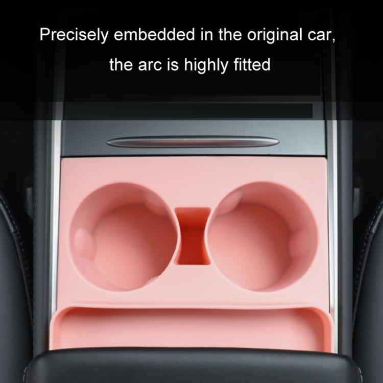 Pink silicone dual cup holder insert installed in car armrest storage compartment