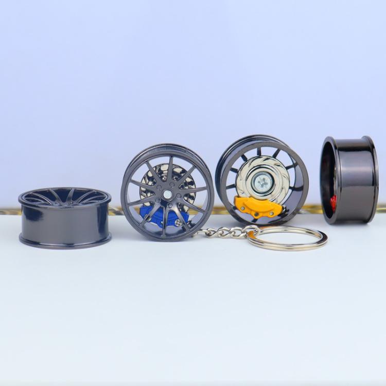 Metal wheel hub brake keychain with black rim and yellow brake caliper, silver key ring