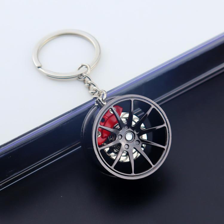Wheel hub brake keychain with black rim and red brake caliper, silver key ring on car door