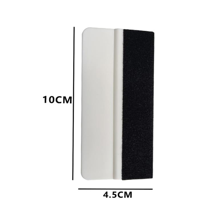 Two-sided felt scraper pad, white and black, approx 10 cm by 4.5 cm