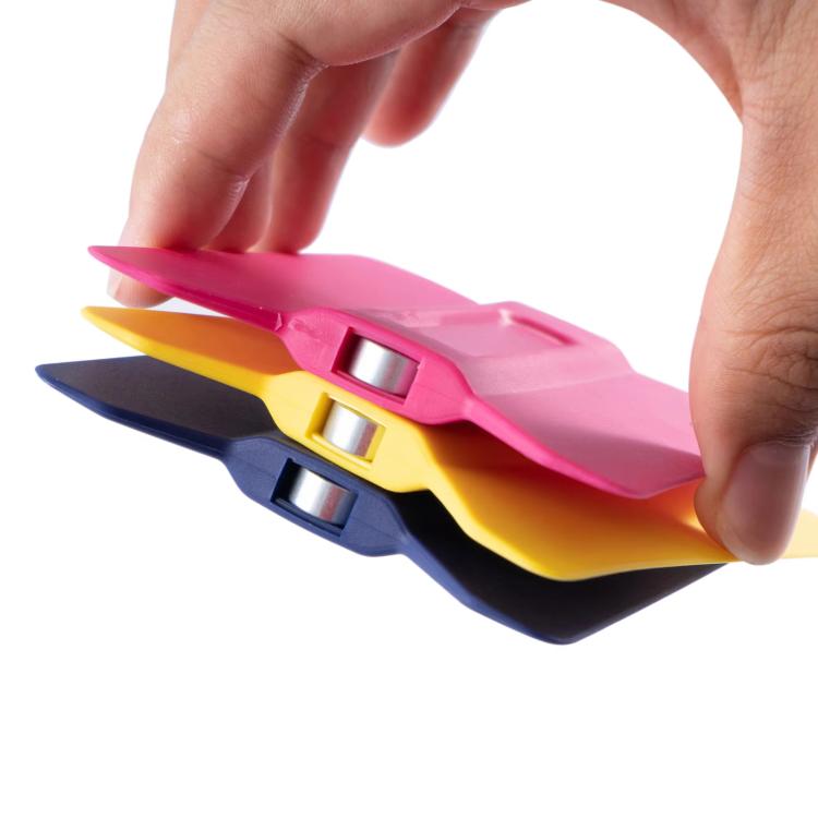 Hand holding colored winged car film scraper tools with metal rollers