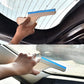 Car window cleaning wiper tool with blue edge held in hand against windshield