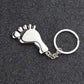 Silver metal foot-shaped keychain charm with round keyring