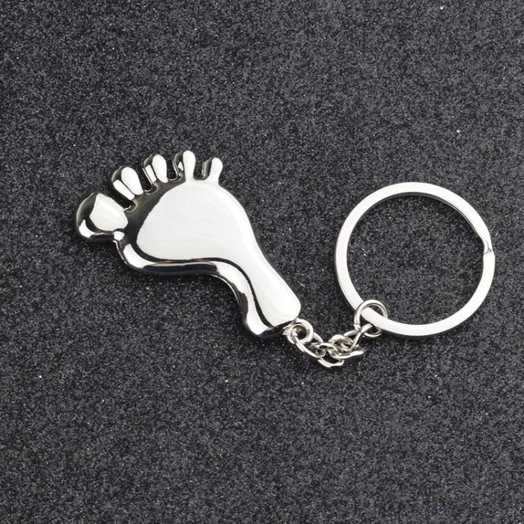Silver metal foot-shaped keychain charm with round keyring