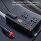 Black car inverter charger on dashboard with AC outlets, voltage display, and USB ports