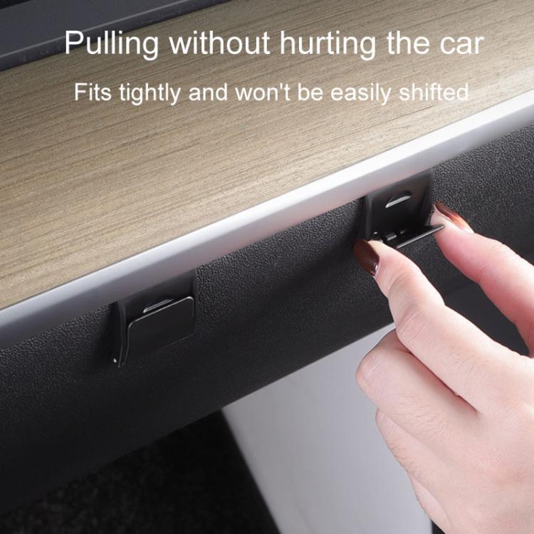 Glove box hook on dashboard panel, hand pulling to adjust