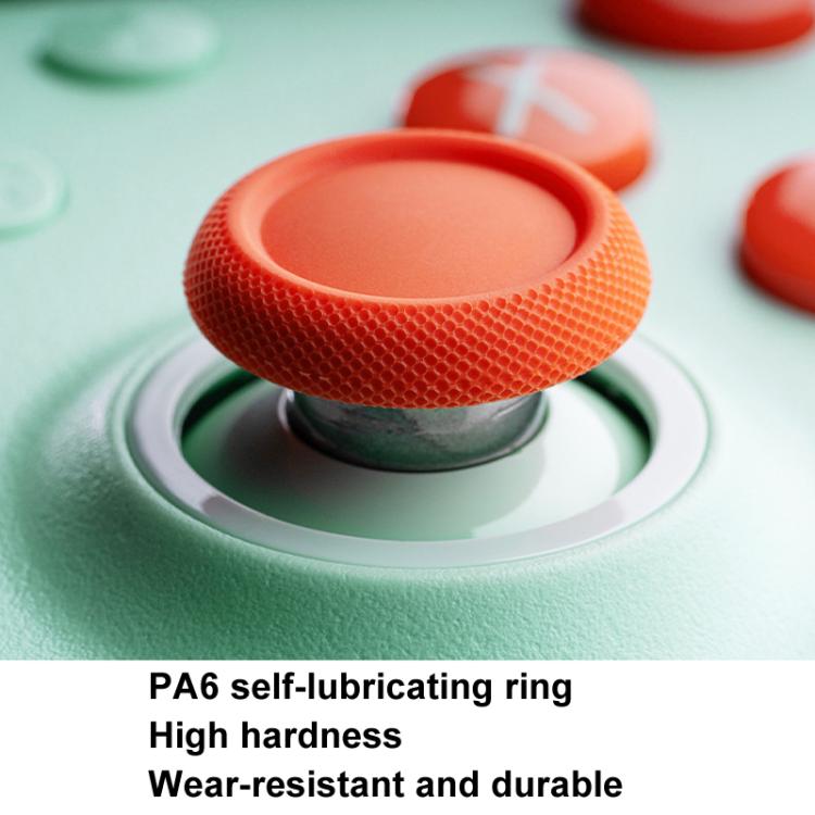 Wireless gaming controller thumbstick detail with textured orange ring on mint base
