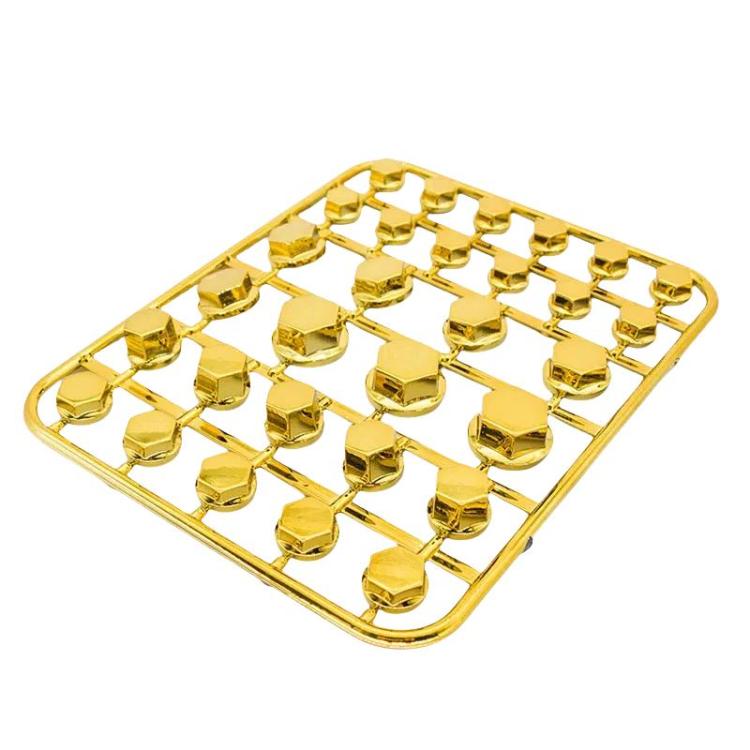Golden decorative hex screw caps in a plastic organizer tray