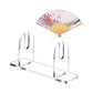 Clear acrylic folding fan display stand holding a folded paper fan on base