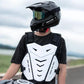 Black motocross rider wearing a white chest armor vest with shoulder straps