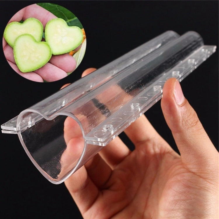 Transparent heart-shaped fruit mold in hand with open heart cavity