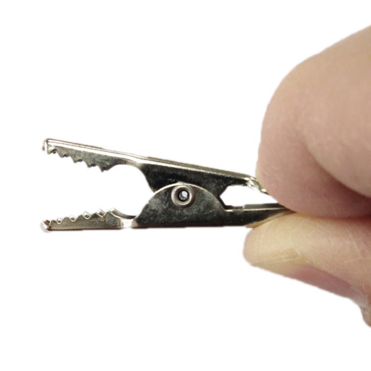 Alligator clip jaws with serrated teeth, pressed by finger