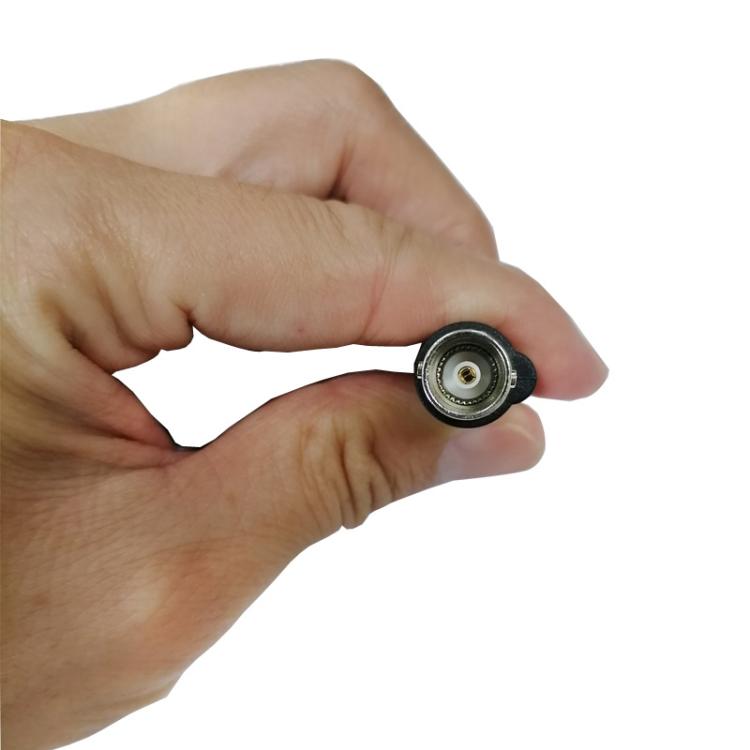 BNC connector on test cable held in hand, metal ring with black housing