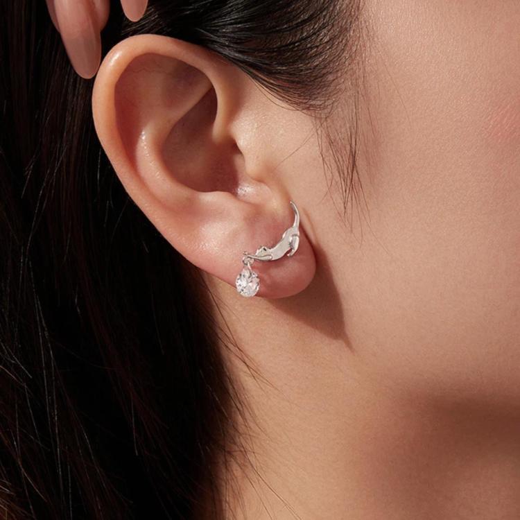 Dachshund charm earrings on ear, silver-tone with round crystal drop
