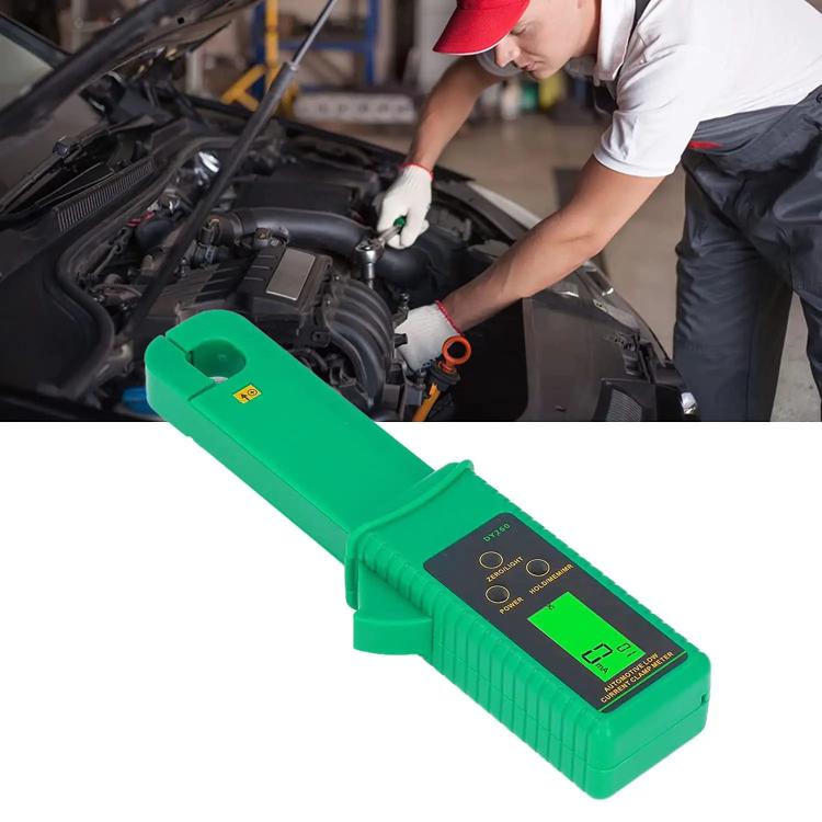 Green clamp meter tester used on a car engine bay with digital display