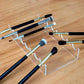 Clear acrylic makeup brush storage stand displaying several brushes in slots