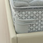 Gray anti-slip sheet clip securing patterned bedding at the edge
