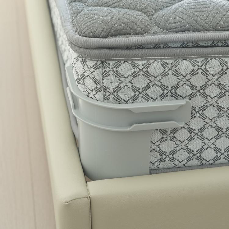 Gray anti-slip sheet clip securing patterned bedding at the edge