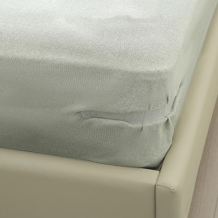 Installed gray anti-slip sheet clip securing sheet corner on a sofa