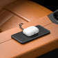 Black wireless charging pad on dashboard with white wireless charger puck