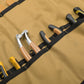 Tan canvas tool pouch interior with black elastic loops holding tool handles