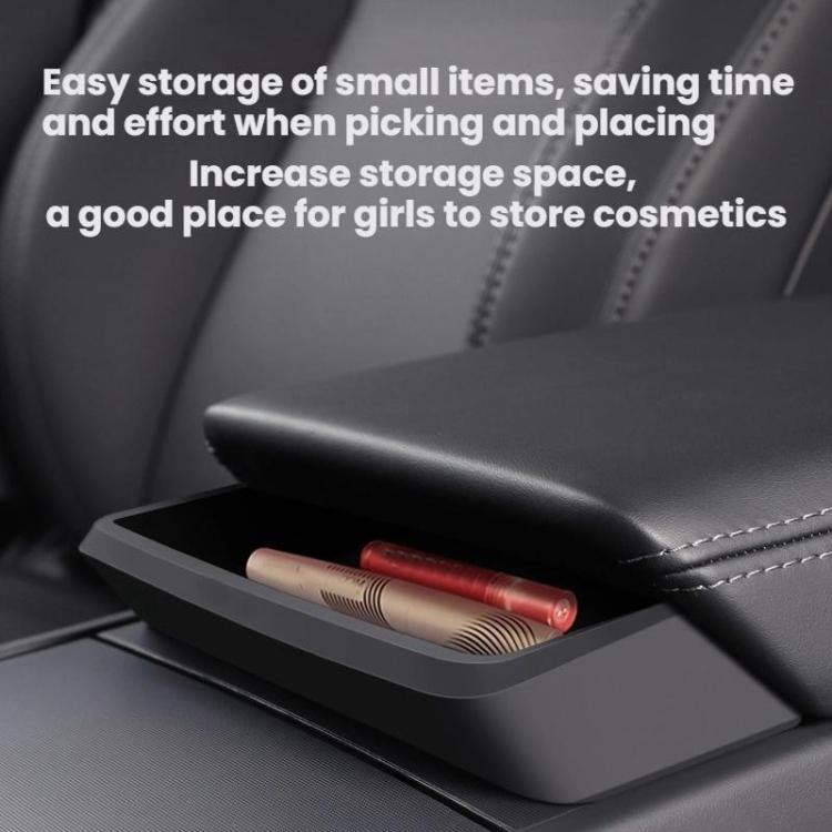 Installed armrest storage drawer holding small items, dark matte black