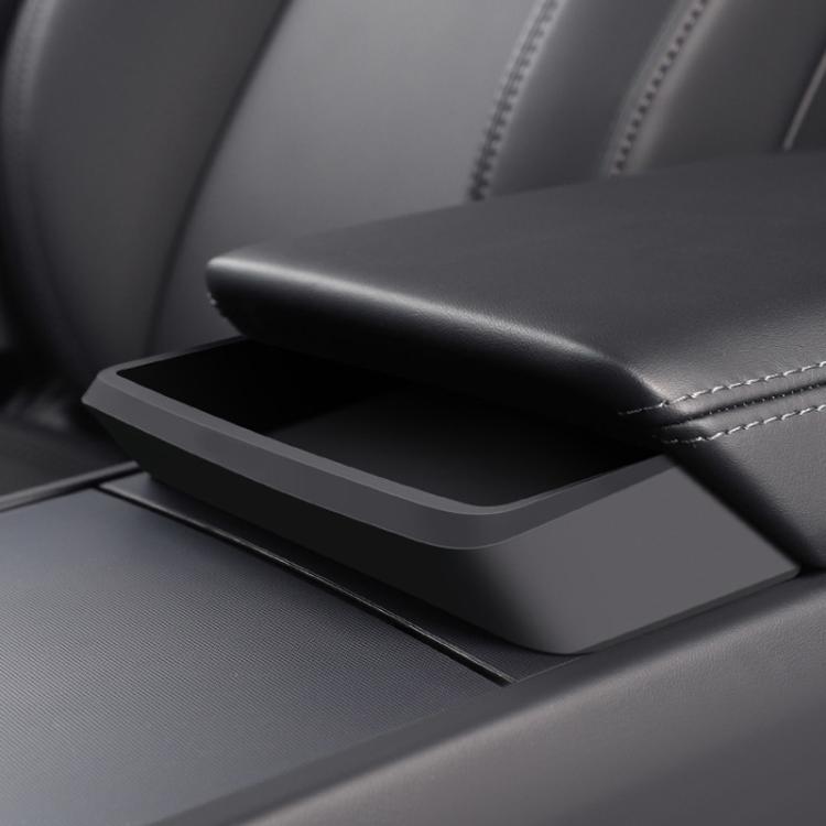 Center console armrest storage tray installed, dark matte black with open lid