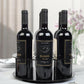 Black round acrylic bottle holder holding three dark wine bottles