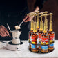 Black round acrylic bottle holder with syrup bottles and gold pump dispensers
