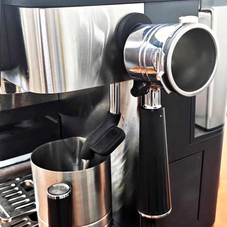 Black magnetic hook on espresso machine securing a metal filter basket