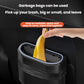 Black car trash can storage box holding a yellow garbage bag under the hinged lid