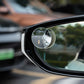 Small round frameless suction-cup mirror attached to a car side window, silver metal rim