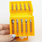 Rotary file set in yellow case held in hand, showing multiple metal bits