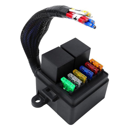 Black motorcycle fuse box with relay and blade fuses on wiring harness