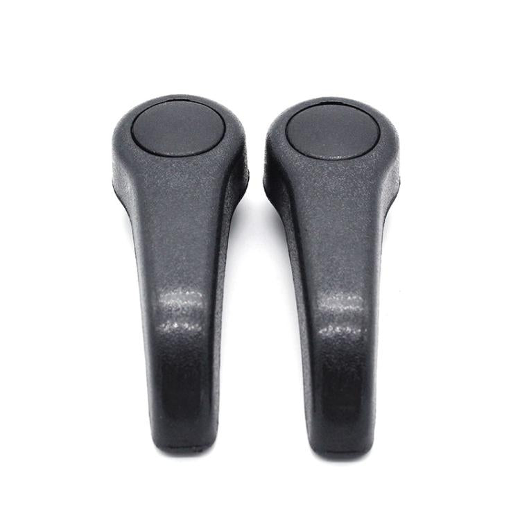 Pair of dark gray seat adjustment lever handles with rounded tops