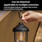 Black portable camping lantern with hanging handle and warm glowing filament bulbs