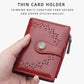 Red women’s short wallet with perforated pattern, snap strap, and side zipper