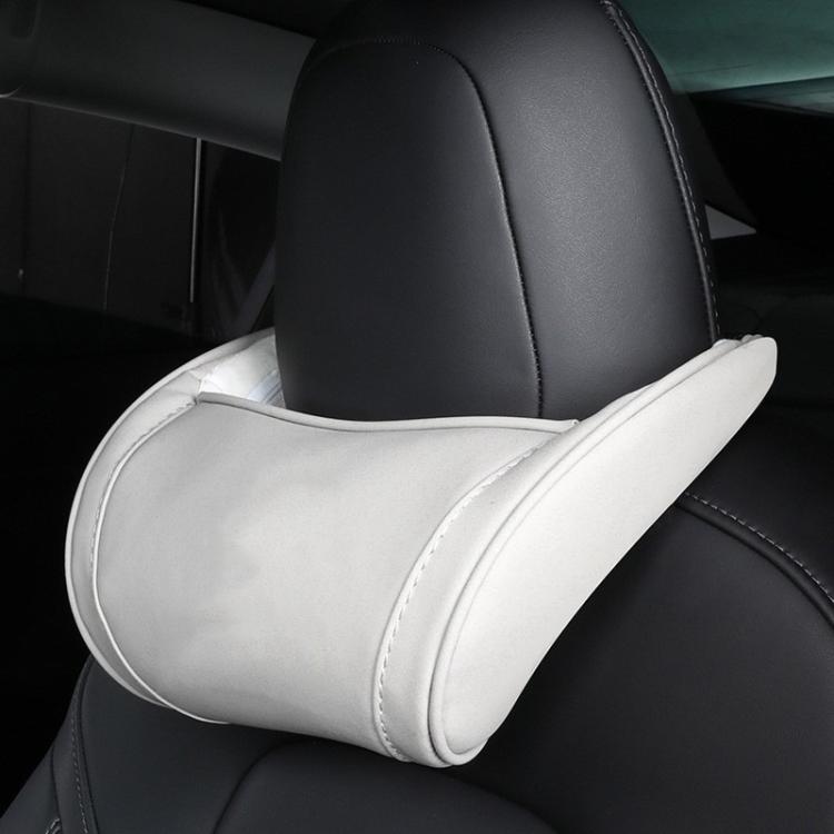 White leather seat neck pillow with light edge stitching on car headrest