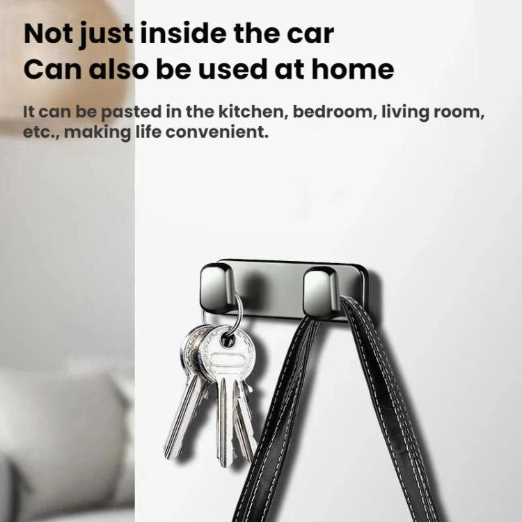 Adhesive hook bar with two hooks holding keys on a wall or door surface